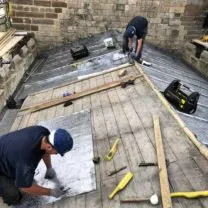 Image showing two of our Lead Workers measuring the Bay lengths ready to boss up and install the new Sandcast lead to the Chancel Roof